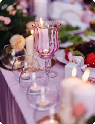 Close-up of pink glass candle holders and floral decor on an event table