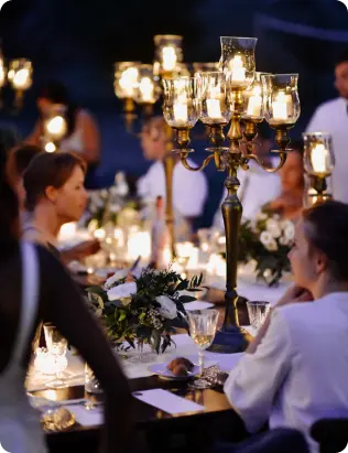 Elegant dining table setup with tall golden candelabras and white floral arrangements