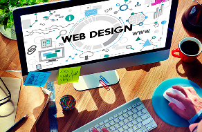 Computer monitor displaying 'WEB DESIGN' graphics and development tools on a creative workspace desk