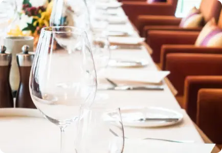 Elegant dining table setup with crystal wine glasses and cutlery for a corporate gala dinner